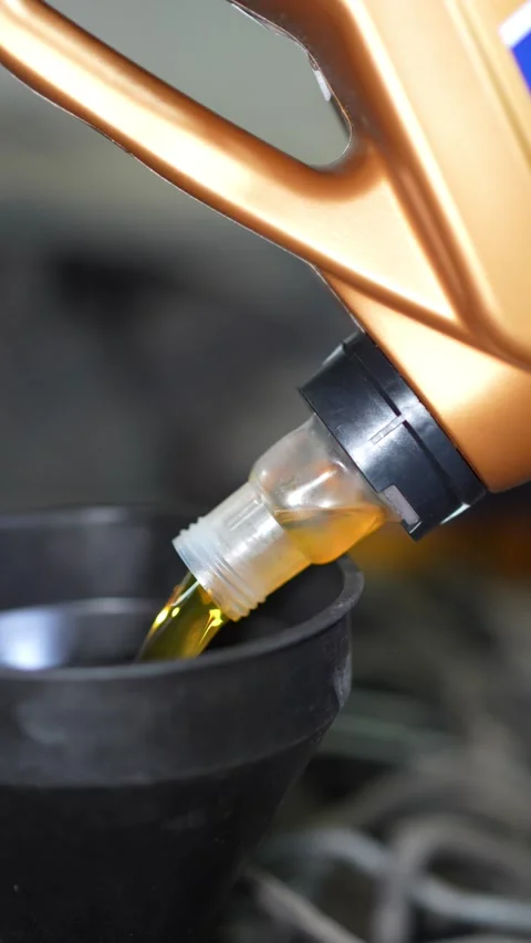 Pouring Engine Oil into Funnel During Auto Maintenance Task Stock Footage 346119879
