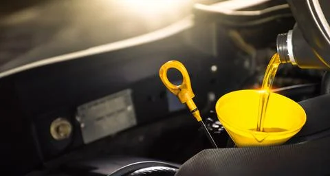 Pouring engine oil into a funnel for engine maintenance include a oil dipstick Stock Photos