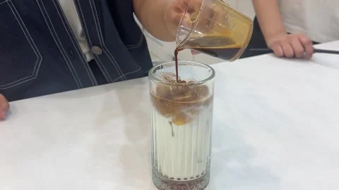 Pouring espresso into iced milk, horizontal view Stock Footage 345159566