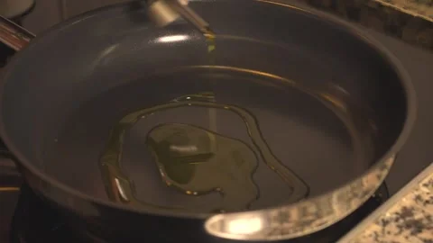 Pouring extra virgin olive oil into a non stick frying pan Vídeos de archivo 331313946