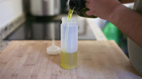 Pouring extra virgin olive oil into squeezer Stock Footage 335834311