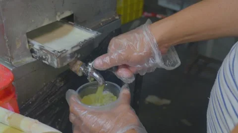 Pouring extracted RAW sugar cain into a cup Video stock 307997823