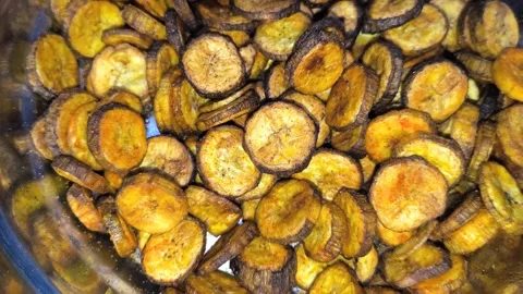 Pouring Finished Banana Chips into Packaging Bags in a Food Plant Stock Footage 326021249