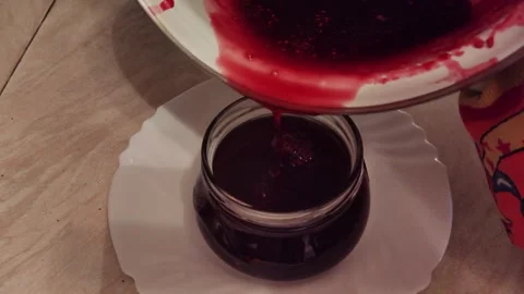 Pouring the finished raspberry jelly into jars. Stock Footage 313430256
