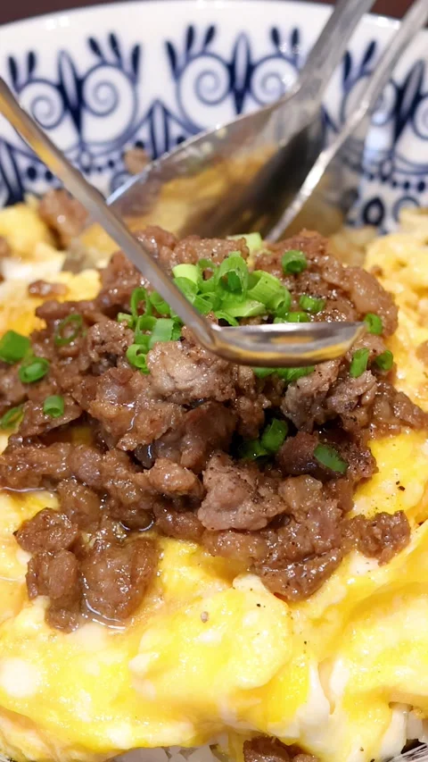 Pouring Fish Sauce Over Beef and Egg Rice Bowl Stock Footage 315013364