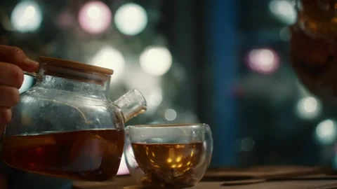 Pouring fragrant tea at a cozy cafe in the evening light Stock Footage 300367604