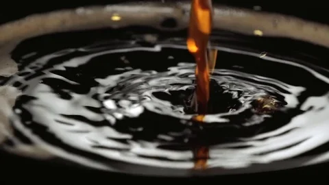 Pouring fresh black coffee in a cup - slow motion shot Stock Footage