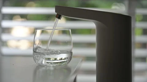Pouring fresh clear water from automatic water cooler Stock Footage 159977845