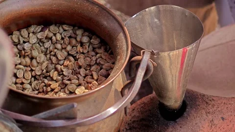 Pouring fresh coffee bean into a pot roaster. Stock Footage 304647316