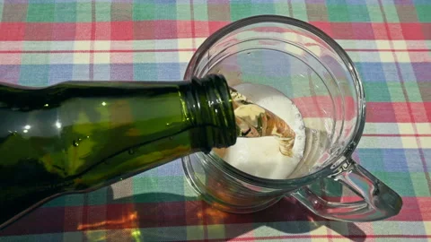 Pouring Fresh Cold Beer from Bottle into Glass on Table Vídeo Stock 335787931