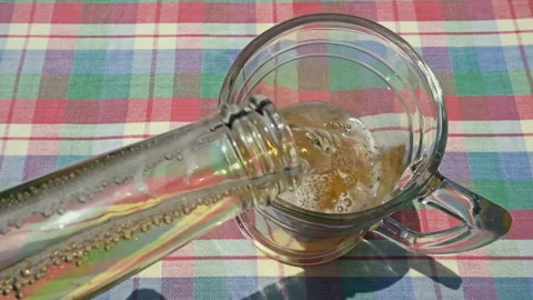 Pouring Fresh Cold Beer from Bottle into Glass on Table Stock-Footage 335787934