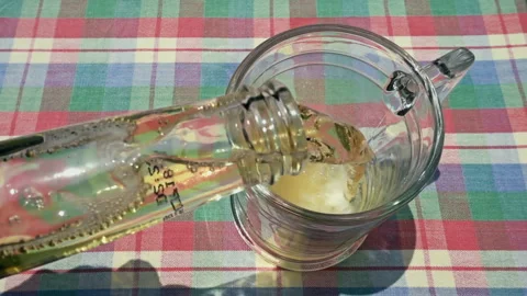 Pouring Fresh Cold Beer from Bottle into Glass on Table Stock-Footage 335787952