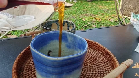 Pouring fresh drip coffee into a handmade ceramic cup outdoors. 스톡 동영상 339780513