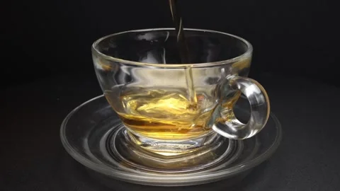 Pouring fresh liquid tea drink into transparent glass tea cup and saucer ro.. Stock Footage 263186038