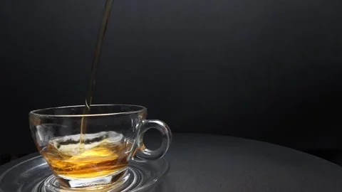 Pouring fresh liquid tea drink into transparent glass tea cup and saucer fr.. Stock Footage 263186043