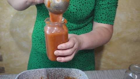 Pouring freshly made tomato ketchup into a jar Video stock 327308564