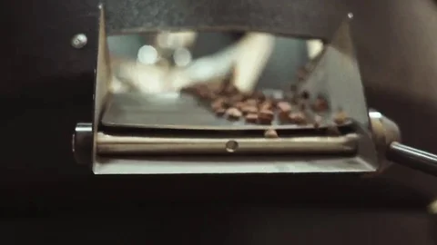 Pouring of freshly roasted coffee beans out of the cooling, mixing machine Stock Footage 69084577