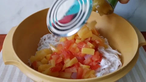 Pouring Fruit Cocktail in Can inside A Mixing Bowl with Shredded Coconut Stock Footage 166566186