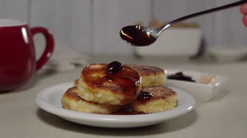 Pouring fruit jam onto a cheese pancake Stock Footage 122287024