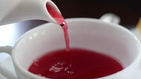 Pouring of fruit red tea into a white mug from a teapot made of porcelain. Stock Footage 102625905
