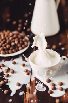 Pouring a glass of milk creating splash Фото