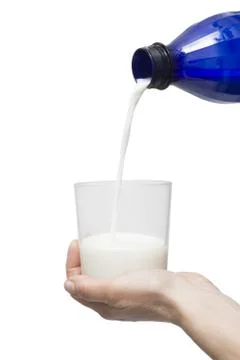 Pouring a glass of milk in the hand from bottle Stock Photos