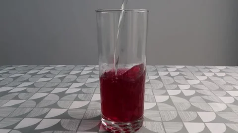 Pouring a glass of red black current fruit cordial squash into a tall glass. Stock Footage 145529853