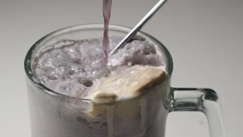 Pouring grape soda over ice cream to create a float. Stock Footage 345367032