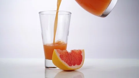 Pouring Grapefruit Juice in a Glass Stock Footage 123721971