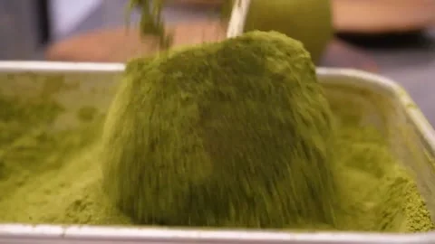 Pouring Green Matcha Powder Over Apple on a Stick Stock Footage 345292789