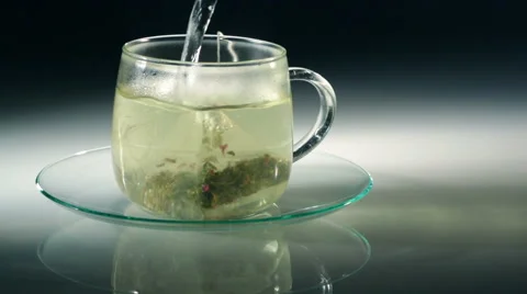 Pouring Green tea in cup with pyramid bag Vídeo Stock 57723357