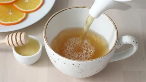 Pouring green tea in a cup. Slow motion. Stock Footage
