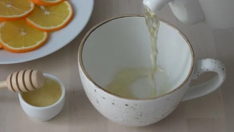 Pouring green tea in a cup. Slow motion. Stock Footage 231795166