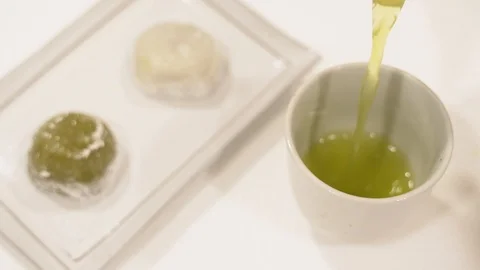Pouring green tea  in white cup japanese moji deseert teapot Stock Footage 109855855