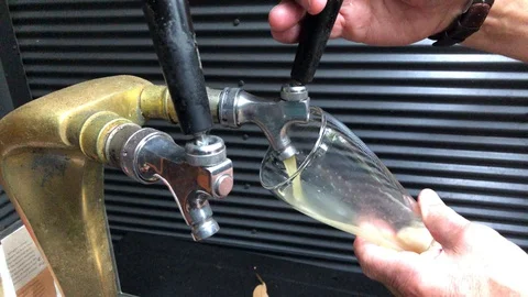 Pouring homebrew beer from taps into glass Stock Footage