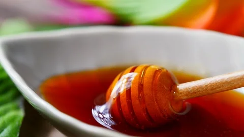 Pouring from honey dipper in leaf shape bowl. Honey dripping Stock-Footage 113940172