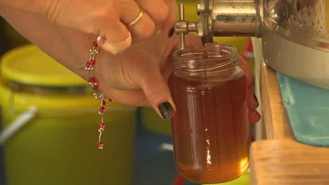 Pouring honey in a jar  Stock Footage 74055580