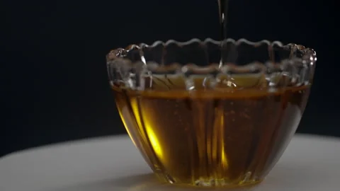 Pouring honey Put in an empty glass cup. Stock Footage 252424155