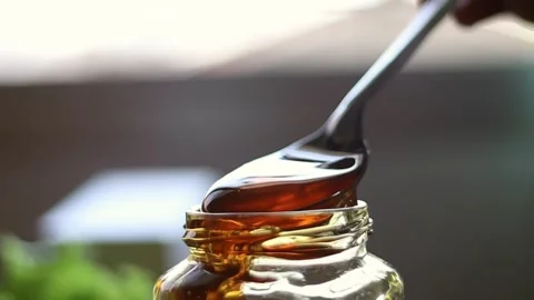 Pouring honey on reflective surface. Shot with high speed camera.Slow Motion. Stock Footage 163569010