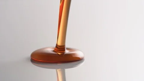 Pouring honey onto reflective surface. Slow Motion. Video stock 121485995