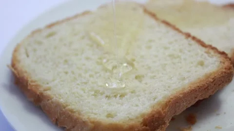 Pouring honey on a slice of bread _3 Video stock 8519077