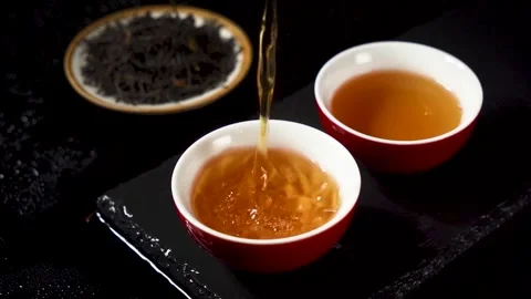 Pouring Hot Black Tea into Ceramic Cup in Slow Motion Stock Footage 341926222