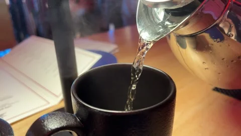 Pouring hot coffee into black coffee cup, mug with on old wood table in morning Stock Footage 292685543