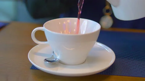 Pouring hot fruit tea to the cup in 4k slow motion 60fps Stock Footage 152569388