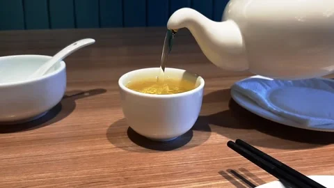 Pouring Hot Green Tea From White Ceramic Teapot To Cup Macro Closeup Slow Motion Stock Footage 323922767