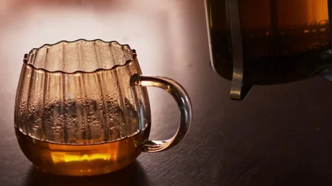 Pouring hot herbal tea into transparent glass cup, close up Stock Footage 345831664