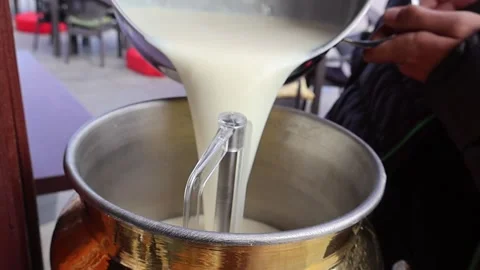 Pouring hot milk mixture into Large Boiler for Traditional Salep Preparation Stock Footage 322534762