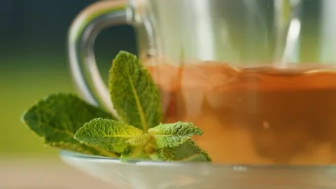 Pouring hot tea in cup close-up. Fresh mint herbal tea ceremony process, healthy Stock Footage 195118719