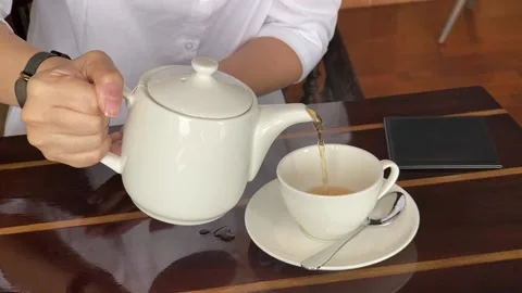 Pouring hot tea into a cup Video stock 208936705
