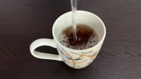 Pouring hot tea into a cup Stock Footage 325316676